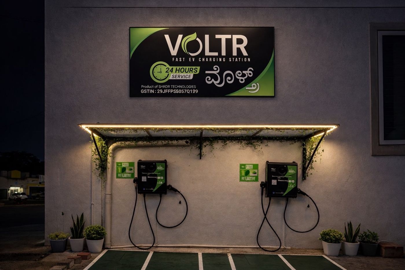 VOLTR charging station at night, with two wall-mounted chargers under a lit canopy and the 24-hour service signboard
